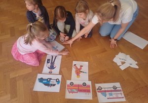 Nauczycielka i dzieci wspólnie układają puzzle.