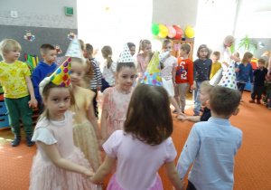 Grupa innych dzieci trzyma się za ręcę.