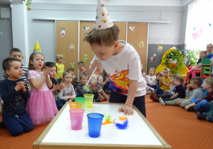 Chłopiec dmucha powietrze do słomki.