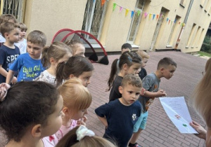 Dzieci stoją wspólnie na tarasie przedszkola.