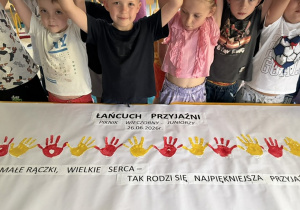 Dzieci trzymają się za ręce i tworzą łańcuch przyjaźni.