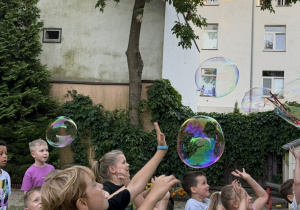 Dzieci bawią się bańkami.