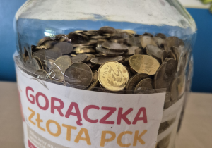 Zdjęcie słoika z groszami.