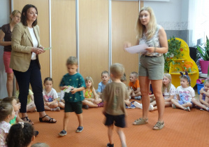 Pani wicedyrektor i nauczycielka stoją w otoczeniu siedzących dzieci.