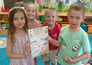 Czworo dzieci stoi obok siebie i trzyma plakat.
