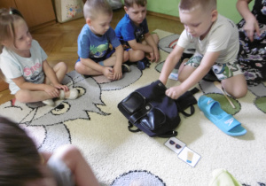 Dzieci podczas wspólnego pakowania plecaka.