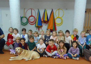 Grupa dzieci siedzi razem na ławce.