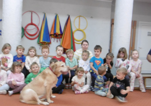 Kolejna grupa dzieci siedzi na ławce obok Pana ze Straży Miejskiej.