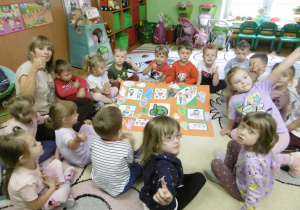 Dzieci siedzą wokół wspólnie wykonanej pracy.