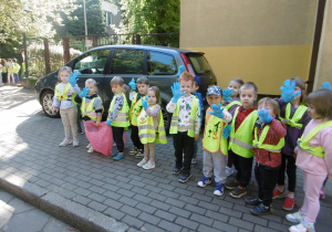 Kolejna grupa dzieci stoi przed wejściem do przedszkola.