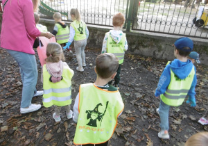 Kolejna grupa dzieci wrzuca śmieci do worka.