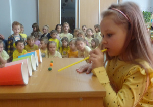 Dziewczynka podczas dmuchania przez słomkę.