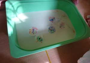 Kolorowe waciki w plastikowym pojemniku.