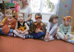 Inna grupa dzieci siedzi obok siebie.