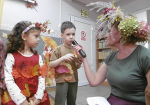 Nauczycielka rozmawia z dwójką dzieci.