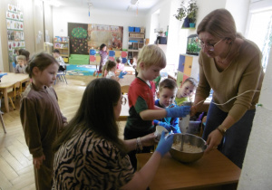 Dzieci wspólnie z nauczycielką miksują warzywa.