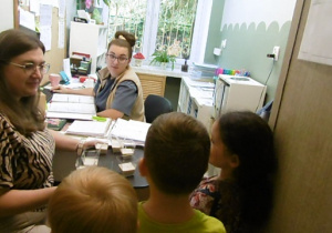 Nauczycielka i dzieci częstują sokiem panią intendent.