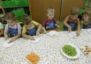 Kolejna grupa dzieci kroi owoce.