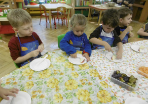 Kolejna grupa dzieci kroi owoce.