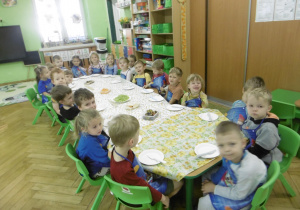 Dzieci siedzą przy stole.