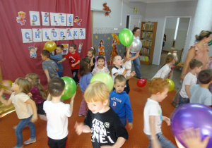 Grupa dzieci podczas zabawy z balonami.