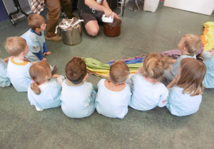 Kolejna grupa dzieci siedzi przy osobie prowadzącej warsztaty.
