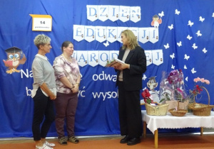 Pani dyrektor gratuluje pracownikom nagrody.