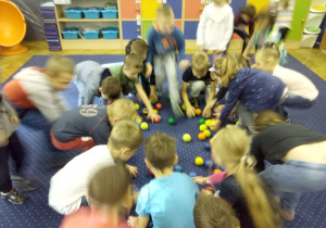 Juniorzy w swojej sali wykonują ćwiczenia gimnastyczne pokazane na tablicy interaktywnej