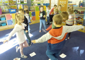 Juniorzy w swojej sali wykonują ćwiczenia gimnastyczne pokazane na tablicy interaktywnej
