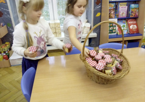 Juniorzy wkładają przygotowane słoiczki z miodem do koszczyczka