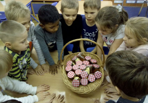 Juniorzy wkładają przygotowane słoiczki z miodem do koszczyczka