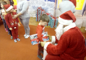 chłopczyk odbiera prezent od Św. Mikołaja