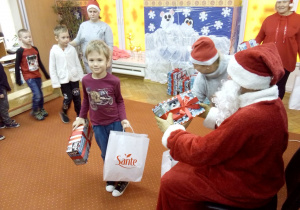 chłopczyk odbiera prezent od Św. Mikołaja