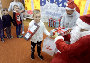 chłopczyk odbiera prezent od Św. Mikołaja