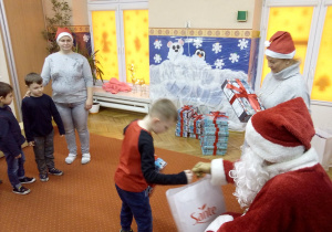 chłopczyk odbiera prezent od Św. Mikołaja