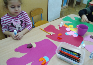 Smyki przy stoliczkach przygotowują dekorację do przestawienia z okazji Dnia Babci i Dzadka