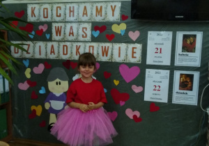 dziewczynka w kolorowym stroju podczas recytacji wiersza dla Babci i Dziadka