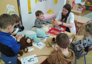 Smyki przy stoliczkach słuchają opowiadania studentek