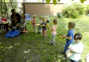 Tuptusie w ogrodzie przedszkolnym podczas zajęc Capoeira graja na instrumentach perkusyjnych