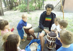 Tuptusie w ogrodzie przedszkolnym podczas zajęc Capoeira graja na instrumentach perkusyjnych