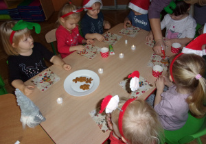 dzieci ozdabiają pierniczki przy stoliczkach