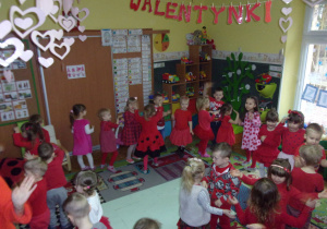 zabawy walentynkowe - Smyki i Tuptusie ubrane na czerwono w kole na dywanie