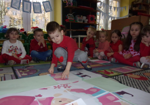 zabawy walentynkowe - Smyki i Tuptusie ubrane na czerwono w kole na dywanie
