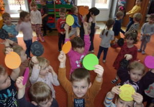 zbawy na sali gimnastycznej - dzieci trzymają w rękach koła o różnych wzorach