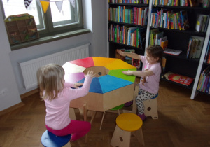 dwie dziewczynki przy tęczowym pudełku