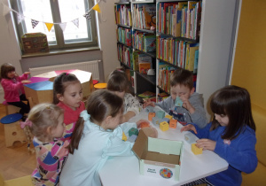 dzieci przy stoliku bawią się klockami
