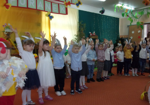 dzieci w opaskach zajączków z podniesionymi rękoma