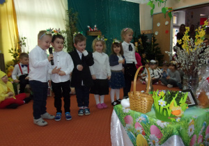 dzieci w galowych strojach śpiewają piosenkę