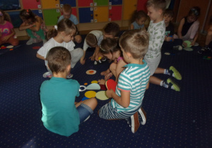 Juniorzy na dywanie ukłądają kompozycje z kropek dużych i małych