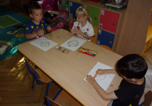 Żaczki przy stolikach wykonują pracę plastyczną